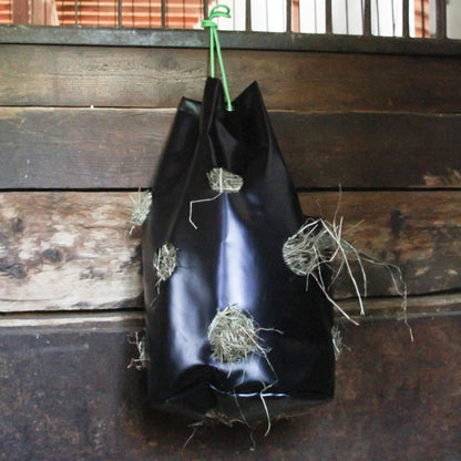 HayBag Heutasche aufgehängt im Stall zur langsamen Heuaufnahme für Pferde